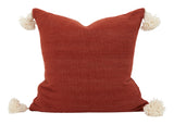 Bashir Floor Cushions, crafted from hand-spun, hand-dyed wool on traditional wooden looms in Morocco, feature a hidden zipper closure, a plush down and feather pillow insert, and charming pom-pom tassels in contrasting hues of ivory and Bordeaux.